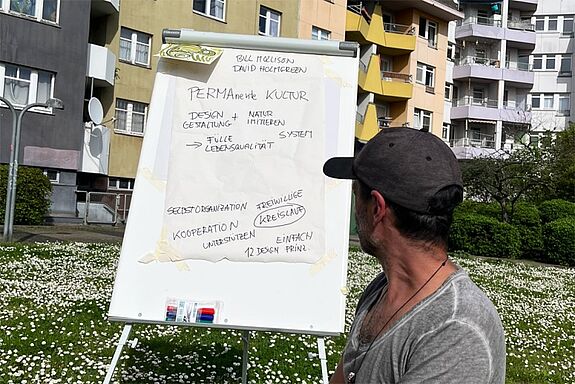 Ein Mitglied des Kollektivs Anemone erklärt nachhaltige Gartenbewirtschaftung während einer Gartensprechstunde. (Bild: Julian Krischan)