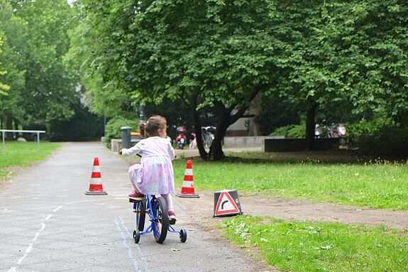 Ein kleines Mädchen fährt begeistert durch den Fahrradparcours, der speziell für die jüngsten Teilnehmenden aufgebaut wurde. (Bild: QM Dammwegsiedlung/ Weiße Siedlung)
