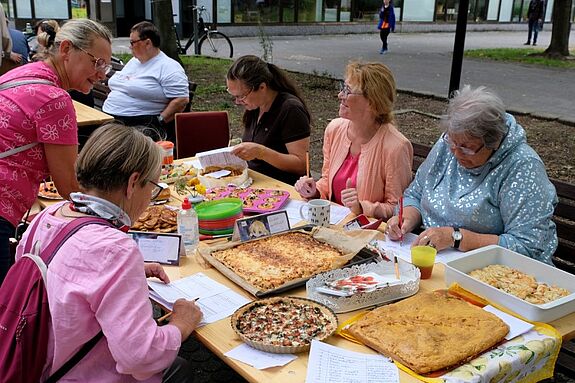Die Jury bewertet die zehn Einreichungen des Kuchenwettbewerbs, der unter dem Motto „Zwiebelkuchen, Quiche und Co.“ stattfand. (Bild: Julian Krischan)