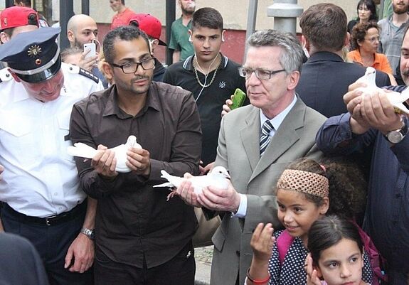 Yousef Ayoub (2.v.l.) mit Bundesinnenminister Thomas de Maizière  (2.v.r.) bei einer gemeinsamen Aktion für ein friedliches Miteinander im Soldiner Kiez. Foto: KbNA e.V.