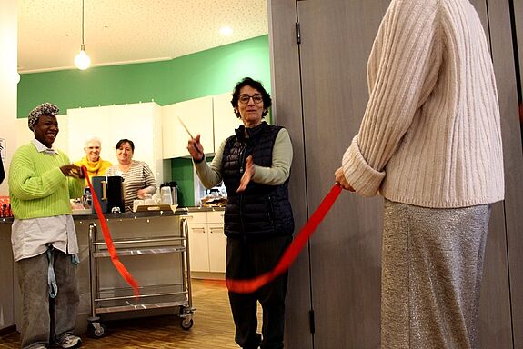 Isabel Carrillo von der Senatsverwaltung für Stadtentwicklung, Bauen und Wohnen schneidet ein rotes Band zur Eröffnung des sanierten Kieztreffs in der Thermometersiedlung durch.