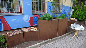 Die wellenförmigen Sitzelemente am Mehrgenerationenhaus Wassertor sind an die Gestaltung des Gebäudes und des Logos der Einrichtung angepasst. (Bild: Julian Krischan)