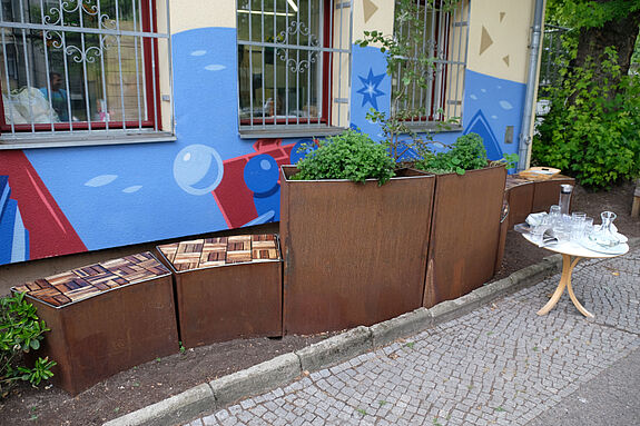 Die wellenförmigen Sitzelemente am Mehrgenerationenhaus Wassertor sind an die Gestaltung des Gebäudes und des Logos der Einrichtung angepasst. (Bild: Julian Krischan)