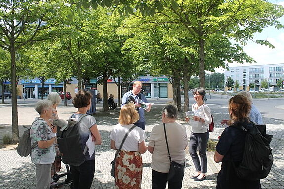 Auf dem Fritz-Lang-Platz macht die Gruppe ihren ersten Stopp. Bild: Kiezredakteur.