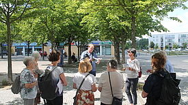 Auf dem Fritz-Lang-Platz macht die Gruppe ihren ersten Stopp. Bild: Kiezredakteur.