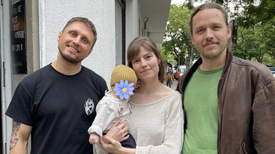 Drei Erwachsene und ein Kleinkind stehen vor einem Hauseingang in der Nazarethkirchstraße.