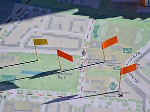 Verschiedenfarbige Fähnchen sind in eine Karte des Stadtquartiers eingesteckt. Der Kartenausschnitt zeigt die Gegend rund um den Von-der-Schulenburg-Park.