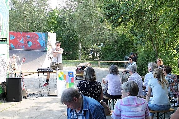 Vor der Kulisse der „Senfte 10“ unterhielt Künstler Friedel das Publikum mit seiner Beatbox: Neben elektronischen Beats als erzeugte Friedel unterschiedliche Klänge allein Mund und Stimme. Bild: Julian Krischan