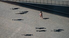 Symbolbild: Menschenschatten und eine Person auf der Straße. Bildnachweis: Cameron Raedius, pexels.com