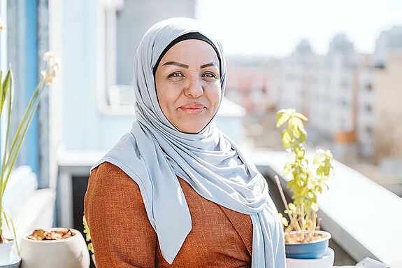 Meriame Haase steht auf einem Balkon in der High-Deck-Siedlung.