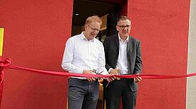 Stadtrat Ephraim Gothe (links) und Romanus Otte von SV Rot Weiß Viktoria Mitte 08 e.V. zerschneiden das Band und eröffnen das Viki-Haus. Foto: Andrei Schnell, QM Brunnenviertel Ackerstraße