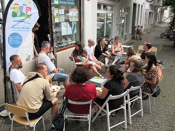 Anwohnende des Harzer Kiezes versammelten sich vor dem Quartiersbüro und genossen das Sommerfest mit Getränken und Gesprächen. (Bild: Jens Sethmann)