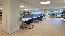 Schreibtische mit Sichtschutz stehen zwischen den Bücherregalen in der Ehm-Welk-Bibliothek.