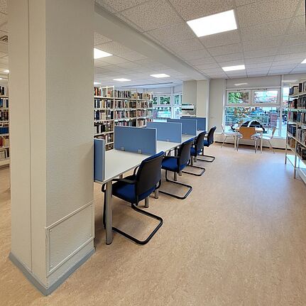 Schreibtische mit Sichtschutz stehen zwischen den Bücherregalen in der Ehm-Welk-Bibliothek.