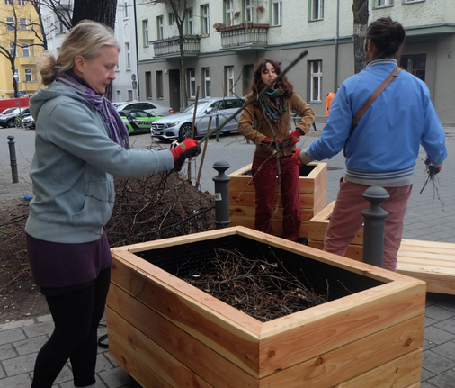 Holzkübel werden bepflanzt. Bild: QM Flughafenstraße / Birgit Leiß.