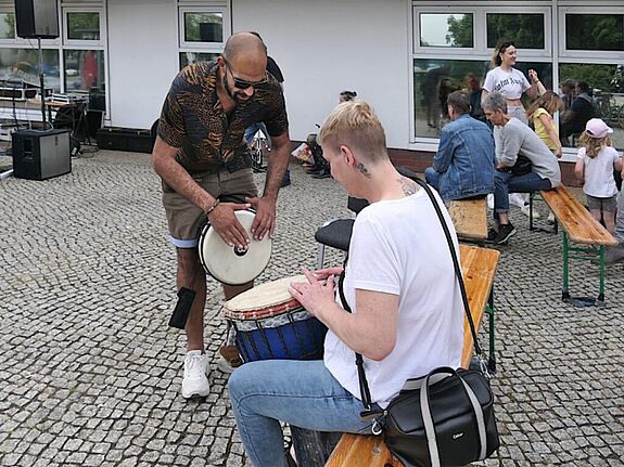 Percussionist Hady Moamen zeigte einer Besucherin, wie man die Trommel richtig spielt und sorgte so für spontane musikalische Einlagen. (Bild: Anka Stahl)
