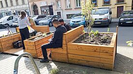 Statt einer ununterbrochenen Reihe von parkenden Autos gibt es in der Stettiner Straße zwei neue Parklets: Stadtmöbel, die zum Verweilen einladen. (Bild: Maja Schudi)