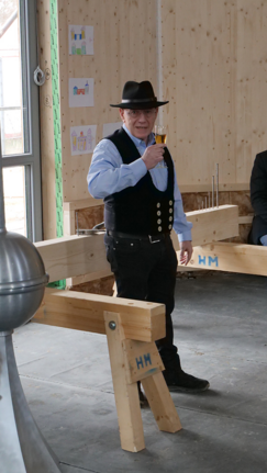 Ein Toast auf den neuen Bau. Im Vordergrund die Dachspitze, in der Münzen und Dokument aufbewahrt werden. Foto: Benjamin Barthmann