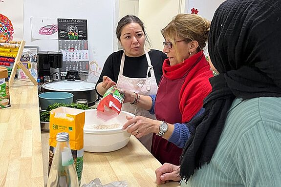 Workshop-Teilnehmende bereiten gemeinsam eine Schüssel mit Zutaten vor.