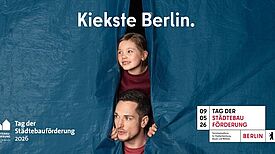 Ein Mann und ein Kind blicken aus einer blauen Plane unter dem Schriftzug „Kiekste Berlin“ hervor.