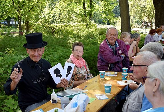 Die Anwesenden konnten sich von einem Scherenschnittkünstler porträtieren lassen. (Bild: QM Gropiusstadt Nord)