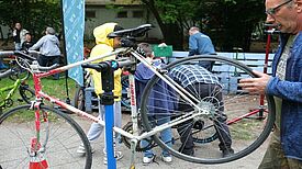 Ein Mechaniker überprüft ein Fahrrad und stellt sicher, dass es für die Radsaison startklar ist. (Bild: QM Dammwegsiedlung/ Weiße Siedlung)