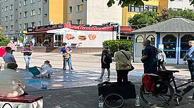 Eine Gruppe Kinder spielt mit dem XXL-Memory während Erwachsene drumherum stehen und zuschauen.