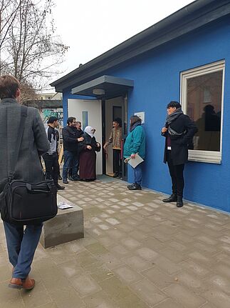 Eine Gruppe von Menschen steht vor dem Rahim-Yildirim-Haus, das gerade durch das Durchschneiden eines Bandes eröffnet wurde. 