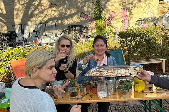 Drei Frauen genießen selbstgemachte gesunde Snacks beim „Recycled Creativity“-Festival.