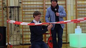 Bezirksstadtrat Jochen Biedermann und Referatsleiter der Senatsverwaltung für Stadtentwicklung und Wohnen Hendrik Hübscher durchschneiden das weiß-rote Band zur symbolischen Einweihung der Räume (v.l.n.r.). Bild: Birgit Leiß 