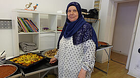 Fatme Hajjaj vor den von ihr zubereiteten Speisen. Bild: QM Donaustraße-Nord