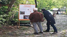 Angemeldete Besucher der Ausstellungseröffnung betrachten eine Schautafel. (Foto: Dominique Hensel)