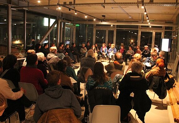 Mehrere Personen sitzen im Kiezsaal des Zentrums für Kunst und Urbanistik und tauschen sich beim Stadtteilplenum Moabit aus.