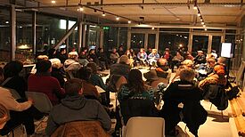 Mehrere Personen sitzen im Kiezsaal des Zentrums für Kunst und Urbanistik und tauschen sich beim Stadtteilplenum Moabit aus.