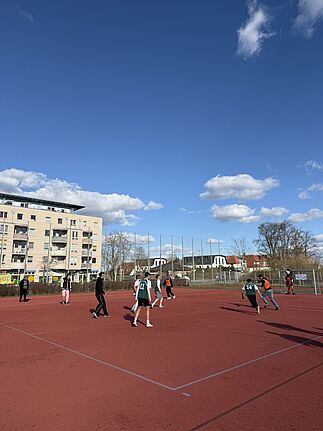 Eine Gruppe Jugendlicher spielt Fußball auf dem Anne-Frank-Sportplatz.