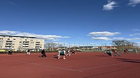 Eine Gruppe Jugendlicher spielt Fußball auf dem Anne-Frank-Sportplatz.