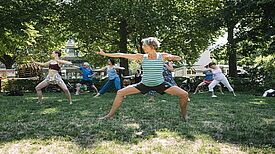 Menschen nehmen an einem Fitnesskurs im Freien im Rahmen des KiezFit-Projekts teil.