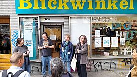 Mehrere Menschen stehen vor dem Büro des Vereins Blickwinkel e.V.[SS28.1] und unterhalten sich. 