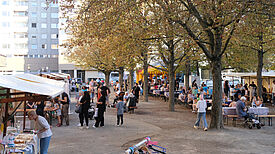 Marktstände mit Menschen auf dem Kastanienplatz.