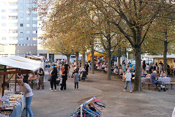 Marktstände mit Menschen auf dem Kastanienplatz.