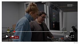 Ein Screenshot des Beitrags über den Begegnungsort in der Hans-Fallada-Schule zeigt wie Anni Dunkelmann und Maria Scurell Snacks für das Winterkino vorbereiten. 