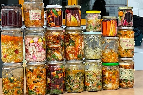 Eine Sammlung von Gläsern mit verschiedenen fermentierten Gemüsesorten.