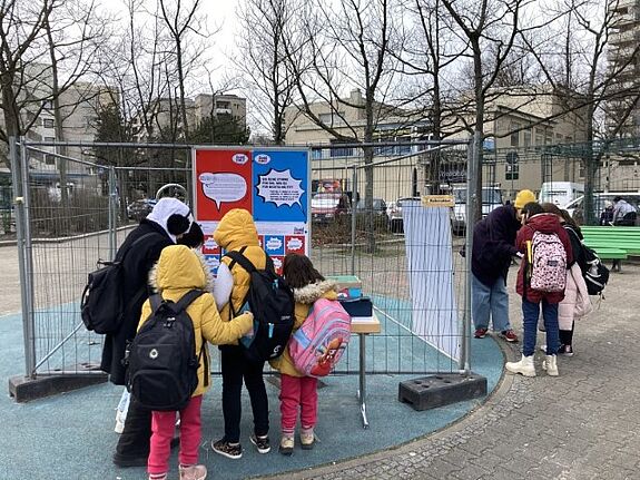 Kinder und Jugendliche stimmten vor der Grundschule in den Rollbergen über die Ideen ab. (Bild: Yazeed Zoumot)