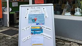Das Willkommensschild am Eingang des TauschTreffs lädt zum Austausch im Nachbarschaftscafé ein und informiert über die Postkarten-Aktion. (Bild: Kerrin Thomsen (NUSZ))
