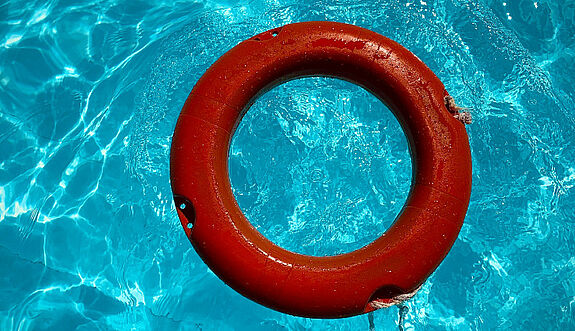 Ein auf dem Wasser schwimmender Rettungsreifen.