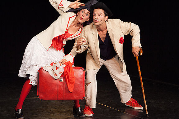 Zwei Schauspielende spielen mit Koffer und Gehstock eine Szene im Theaterprojekt Germaniagarten.
