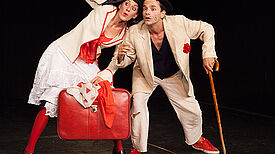Zwei Schauspielende spielen mit Koffer und Gehstock eine Szene im Theaterprojekt Germaniagarten.
