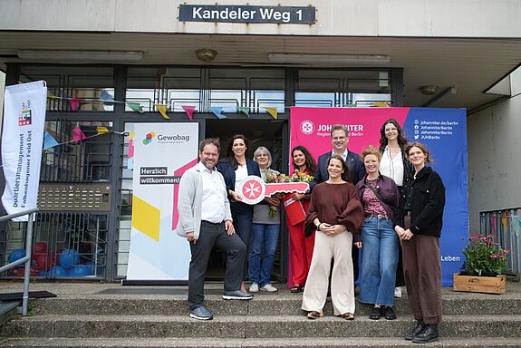 Mehrere Beteiligte stehen vor dem Eingang am Kandeler Weg 1 bei der Eröffnung der Projektwohnung.