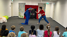 Die Kinder der Kita Schwanheimer Straße proben für das Stück „Abfall KADABRA“ vor einer minimalistischen Kulisse. (Bild: QM Germaniagarten)