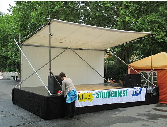 Die Bühne: 4 x 6 Meter, überdacht, robuste Bauweise aus Metall, Holz und einer LKW-Plane. Bild: Informationsbroschüre des Services